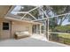 Enjoy outdoor living on the screened-in patio with a comfortable couch, perfect for relaxation and fresh air at 9405 Ashley Dr, Weeki Wachee, FL 34613