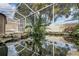 Screened-in patio highlights a tranquil pond, surrounded by rocks and foliage, providing a calming focal point at 9405 Ashley Dr, Weeki Wachee, FL 34613