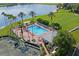 Aerial view of community pool area with lounge chairs, palm trees and nearby tennis courts at 9405 Ashley Dr, Weeki Wachee, FL 34613