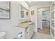 Bathroom with white vanity, updated fixtures, light walls and view to the dining room at 944 Symphony Isles Blvd, Apollo Beach, FL 33572