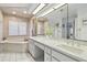 Bright bathroom featuring double vanity with marble countertop, tub, and large mirrors at 944 Symphony Isles Blvd, Apollo Beach, FL 33572