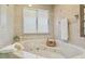 Close-up of a marble bathtub with jacuzzi jets, window, and decorative towels at 944 Symphony Isles Blvd, Apollo Beach, FL 33572