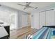 Bedroom featuring light blue walls, wood floors, and a view to the enclosed lanai at 944 Symphony Isles Blvd, Apollo Beach, FL 33572