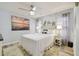 Cozy bedroom with a queen bed, ceiling fan, coastal decor, and wood flooring, creating a serene and inviting space at 944 Symphony Isles Blvd, Apollo Beach, FL 33572