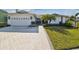 Charming single-story home featuring a well-manicured lawn, brick pathway, and a two-car garage at 944 Symphony Isles Blvd, Apollo Beach, FL 33572
