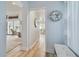 Hallway with light blue walls, wood floors, and view to enclosed lanai and office at 944 Symphony Isles Blvd, Apollo Beach, FL 33572