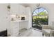 A well-lit kitchenette featuring white cabinetry, a view of the garden, and a cozy seating area at 944 Symphony Isles Blvd, Apollo Beach, FL 33572