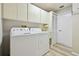 Bright laundry room with sink, washer, dryer, ample storage, and tile flooring at 944 Symphony Isles Blvd, Apollo Beach, FL 33572