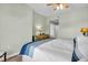 Well-lit bedroom features hardwood floors, ceiling fan, and a white bed with blue accents at 100 4Th S Ave # 202, St Petersburg, FL 33701