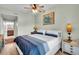 Well-lit bedroom features hardwood floors, ceiling fan, and a white bed with blue accents at 100 4Th S Ave # 202, St Petersburg, FL 33701