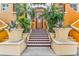 Inviting building entrance with tiled stairs, lush plants and a secure wooden door, creating a welcoming atmosphere at 100 4Th S Ave # 202, St Petersburg, FL 33701