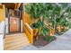 Building entrance featuring a secure wooden door and stairs, complemented by vibrant plants and colorful exterior accents at 100 4Th S Ave # 202, St Petersburg, FL 33701