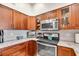 Close-up of a kitchen featuring granite countertops, stainless steel appliances, and wooden cabinetry at 100 4Th S Ave # 202, St Petersburg, FL 33701