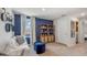 Comfortable room featuring a blue accent wall, beige carpet, neutral furniture, and natural light at 10733 Hidden Banks Gln, Parrish, FL 34219