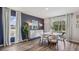 Dining area with white chairs, round table, hardwood floors, white curtains, and blue accent wall at 10733 Hidden Banks Gln, Parrish, FL 34219