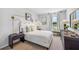 Modern white bedroom featuring unique lighting, a large window, bench seating, and neutral colors at 10734 Hidden Banks Gln, Parrish, FL 34219