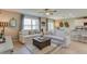 Inviting living room showcasing white sofas, a rustic coffee table, and an open layout to the dining area and kitchen at 10907 Gentle Current Way, Parrish, FL 34219