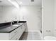 Bathroom featuring double sinks, black countertop, and a glass-enclosed shower, showcasing modern fixtures at 1120 E Kennedy Blvd # 1126, Tampa, FL 33602