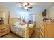 Lovely bedroom with tiled floors, ceiling fan and beautiful wood bed and dressers at 11304 Sedgefield Ave, Spring Hill, FL 34608