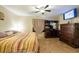 Bedroom features tiled floors, ceiling fan, dark wood dresser and large television at 11304 Sedgefield Ave, Spring Hill, FL 34608