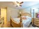 Cozy bedroom features a ceiling fan, closet, and a bed with plush pillows and a decorative quilt at 11304 Sedgefield Ave, Spring Hill, FL 34608