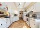 Open concept kitchen with lots of white cabinets, a double bowl sink, and tiled floors at 11304 Sedgefield Ave, Spring Hill, FL 34608