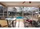 Screened in porch with dining set and other items leading to a private outdoor pool at 11304 Sedgefield Ave, Spring Hill, FL 34608