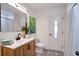 Bathroom featuring patterned floors, wooden vanity, oval window door, modern fixtures, and tiled shower at 11437 59Th Ter, Seminole, FL 33772