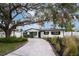 Charming single-story home featuring a long driveway, manicured landscaping, and a shady tree at 11437 59Th Ter, Seminole, FL 33772