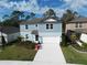 Aerial view of a charming two-story home with a well-manicured lawn and lush landscaping at 11751 Moonsail Dr, Parrish, FL 34219