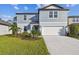 Charming two-story home with a well-manicured lawn, palm trees, and a spacious driveway at 11751 Moonsail Dr, Parrish, FL 34219