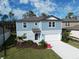 Two-story blue home featuring an attached two-car garage and freshly landscaped front yard on a sunny day at 11751 Moonsail Dr, Parrish, FL 34219