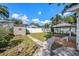 A well-maintained backyard with a shed, manicured lawn, deck, and a white fence ensures privacy at 1210 E Sligh Ave, Tampa, FL 33604