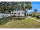 A backyard showcasing the deck, lush grass and mature trees providing ample shade at 1210 E Sligh Ave, Tampa, FL 33604