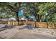 Property featuring a wooden fence, gravel, mature trees, and low-maintenance landscaping, creating a private outdoor area at 1210 E Sligh Ave, Tampa, FL 33604