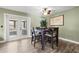 Bright dining room with hardwood floors, a modern table set, and a view of the backyard through French doors at 1314 Oak Valley Dr, Seffner, FL 33584