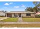 Charming single-story home featuring a stone facade, well-maintained lawn, and a cozy front porch with bench at 1314 Oak Valley Dr, Seffner, FL 33584