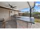 Outdoor kitchen with grill, sink, fridge, and counter space on a brick patio at 1314 Oak Valley Dr, Seffner, FL 33584