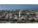 Aerial view of a home, situated close to the water and surrounded by lush greenery and other residences at 1545 Pasadena Dr, Dunedin, FL 34698