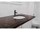 Bathroom featuring a dark granite countertop, modern white cabinets, and white tiled backsplash at 1545 Pasadena Dr, Dunedin, FL 34698