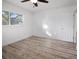 Bright bedroom featuring wood-look flooring, a ceiling fan, and a window with natural light at 1545 Pasadena Dr, Dunedin, FL 34698