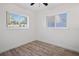 Bright bedroom featuring wood-look flooring and two windows with natural light at 1545 Pasadena Dr, Dunedin, FL 34698