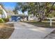 A beautiful blue house with a well-maintained lawn and mature trees, offering great curb appeal at 1545 Pasadena Dr, Dunedin, FL 34698