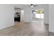 Open living room featuring hardwood floors, a ceiling fan, and a view into the kitchen at 1545 Pasadena Dr, Dunedin, FL 34698