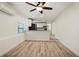 Open living space with wood flooring, ceiling fan, and modern kitchen at 1545 Pasadena Dr, Dunedin, FL 34698