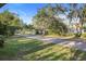 A street view showcases the serene, tree-lined neighborhood with a paved road, offering a tranquil setting at 1545 Pasadena Dr, Dunedin, FL 34698