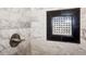 Close-up of a tiled shower showcasing a unique shower niche with decorative tiles and bronze fixtures at 1545 Pasadena Dr, Dunedin, FL 34698