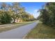 A paved path lined with mature trees, perfect for walking, biking, and enjoying the neighborhood's tranquility at 1545 Pasadena Dr, Dunedin, FL 34698