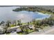 Aerial shot of a lakeside home with mature trees, with a private dock and surrounding lake at 2050 W Bearss Ave, Tampa, FL 33618