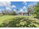 Back exterior of a single-story home with a screened patio and a large, grassy yard at 2050 W Bearss Ave, Tampa, FL 33618